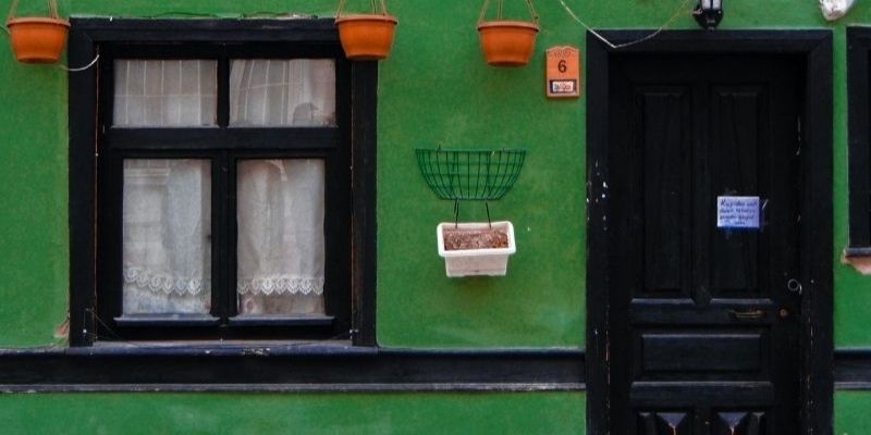 Green building with black trim and a black door