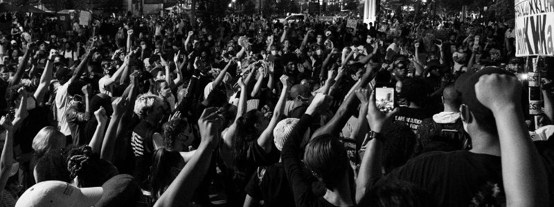 a crowd at a rally of some sort with their hands in the air