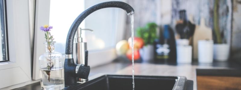 black water faucet running in a kitchen 