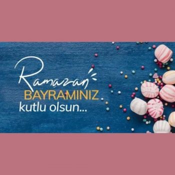 some hard candies on a blue background with Happy Ramadan in Turkish