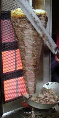 Beef Doner on a spit in front of an electric cooking element