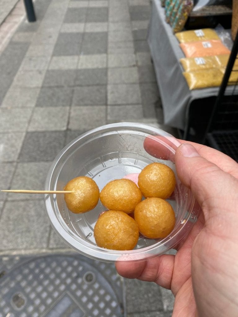 street food - lokma in a plastic container with a toothpick to eat it. 