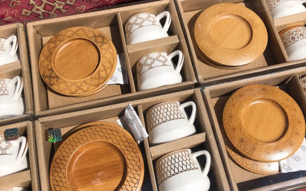 Turkish coffee sets of white cups with gold painting and small wooden plates. 