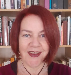 A headshot of Lisa Morrow with books in the background