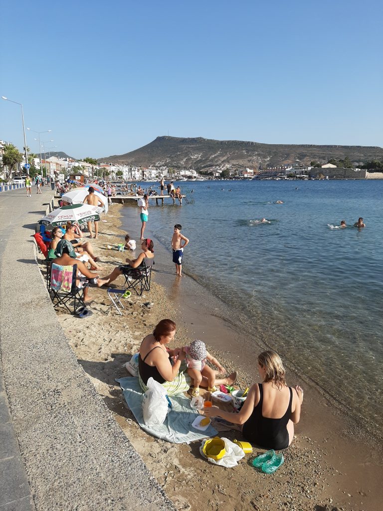 Enjoying the beach in a small coastal town with mountains in the background