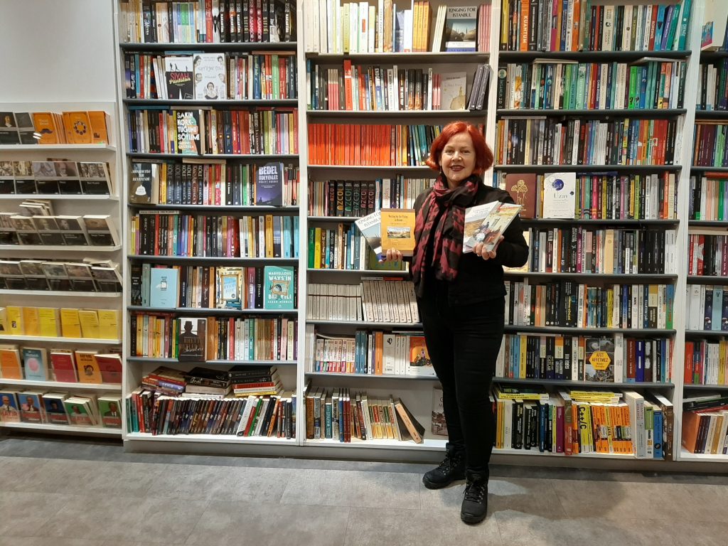 Lisa Morrow holding her published books at Mephisto in Kadikoy