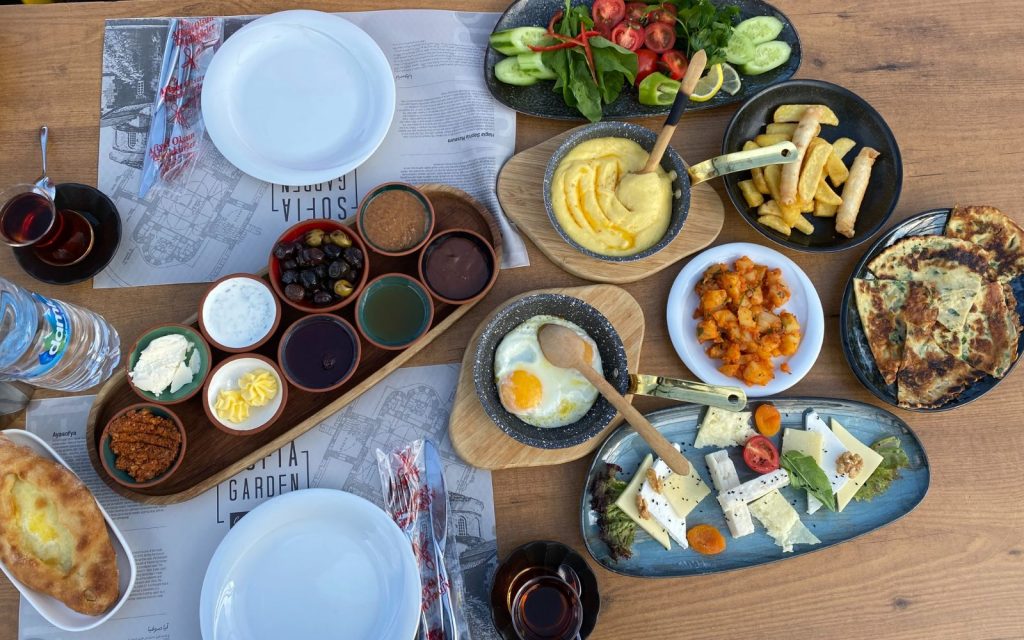 Turkish breakfast spread including an omlet, sauces, potatoes, cheeses and kuymak. 