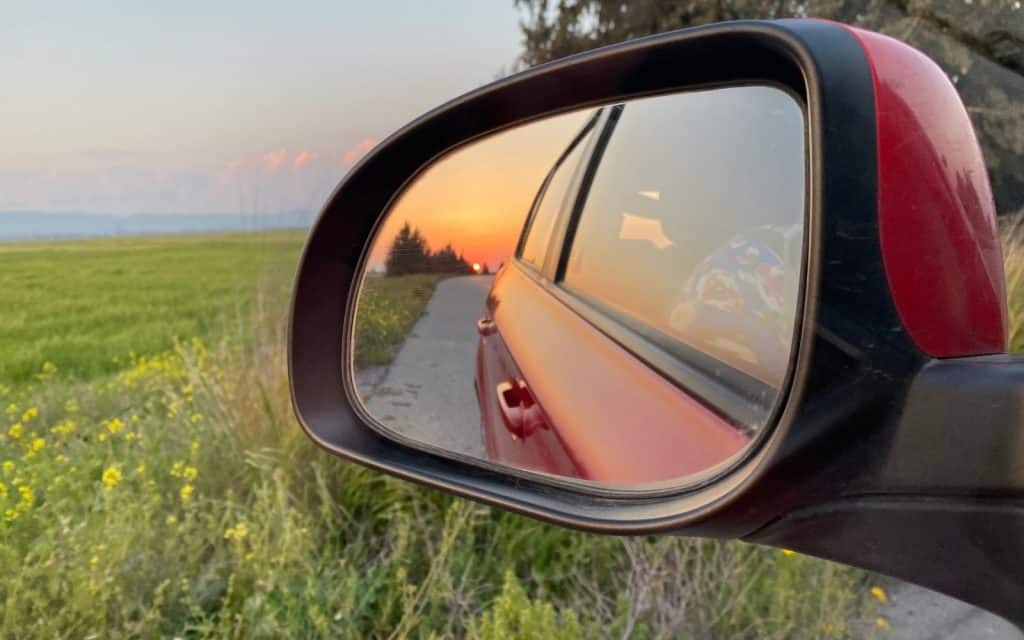 sunset in the side mirror while driving in cyprus