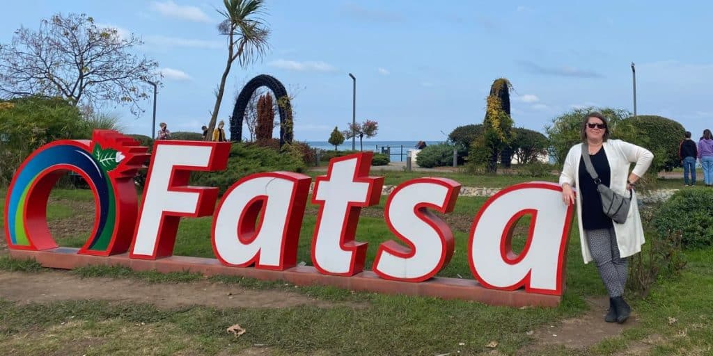 Giant FATSA sign with me standing next to it on a sunny day.