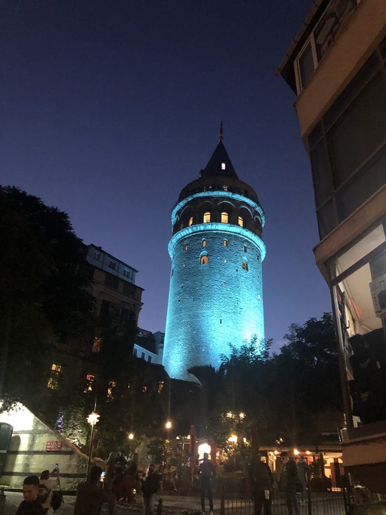 Galata Tower lit up blue at night. 