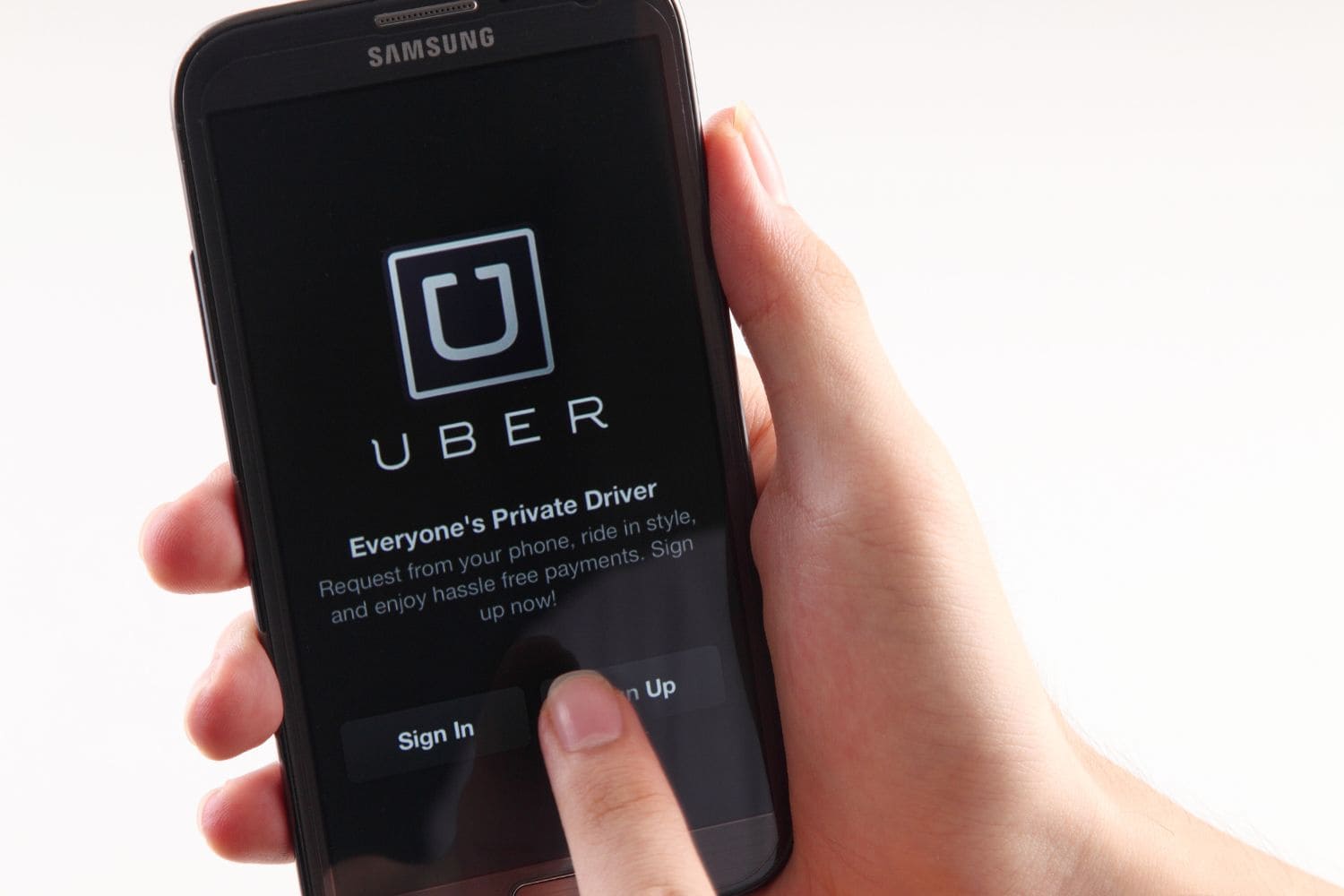 a hand holding a phone with uber in turkey on the phone with a white background