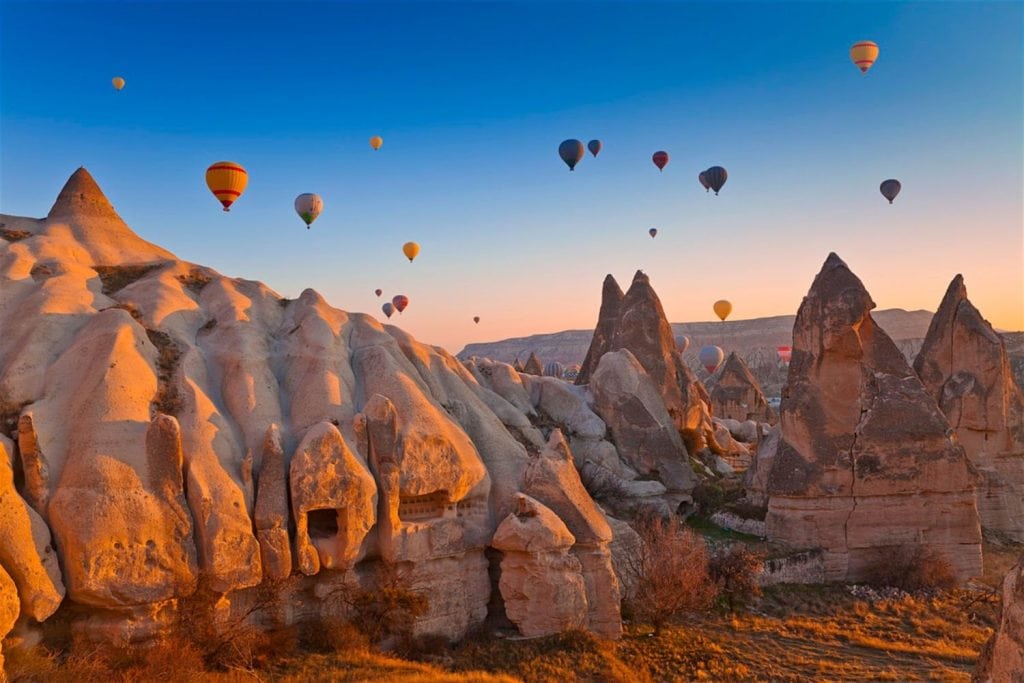 Hot air balloons over the Cappadocian fair chimneys at sunset
