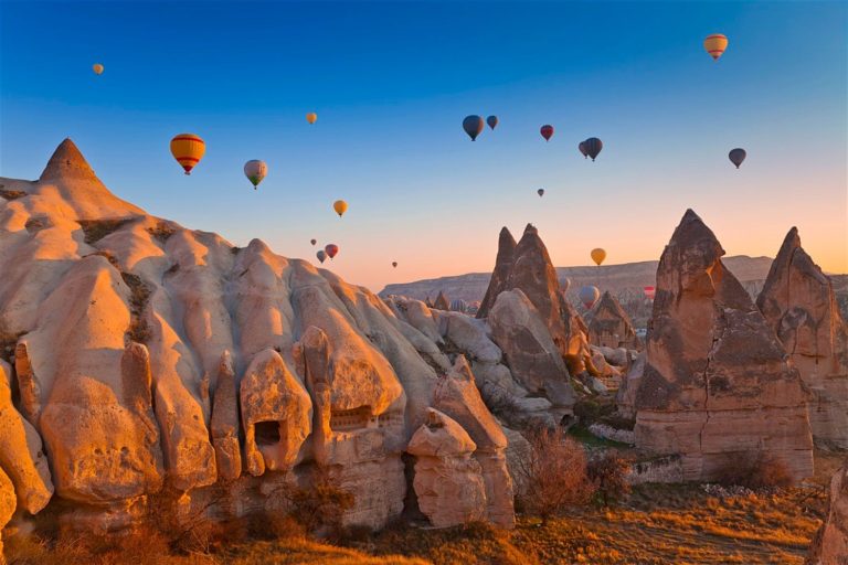 Hot air balloons flying above the fairy chimneys in Cappadocia at sunset. unfortunately Istanbul hot air balloon rides aren't a thing but you can do them in Cappadocia