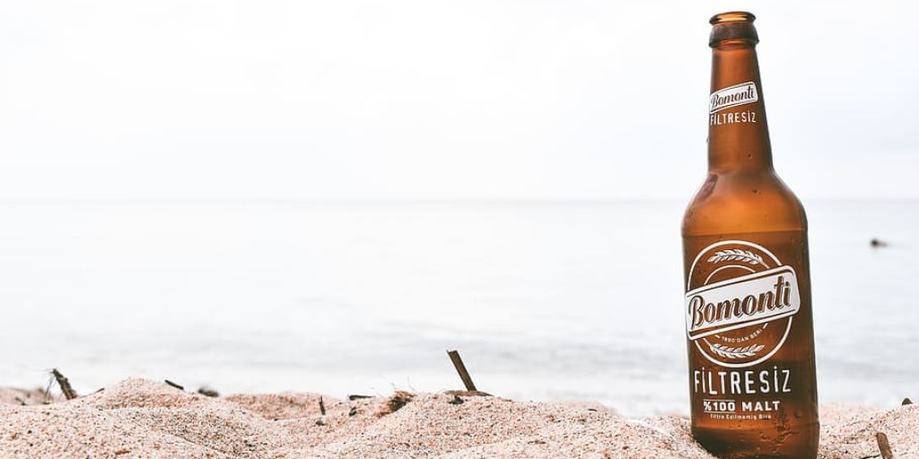 bomonti filtresiz beer tucked in the sand on a beach