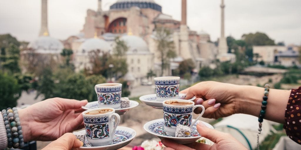 four people drinking Turkish coffee with the Hagia Sophia in the background
