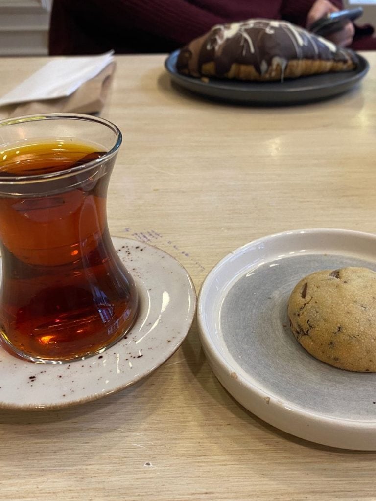 a turkish tea and a small chocolate chip cookie on small serving plates