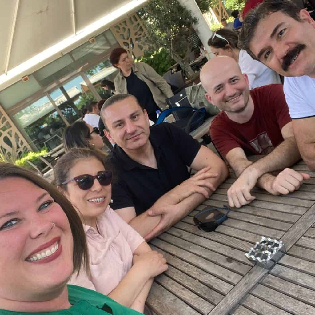 Kimberly sitting at an outside table in Kadıköy with men and a woman from her turkish real estate class