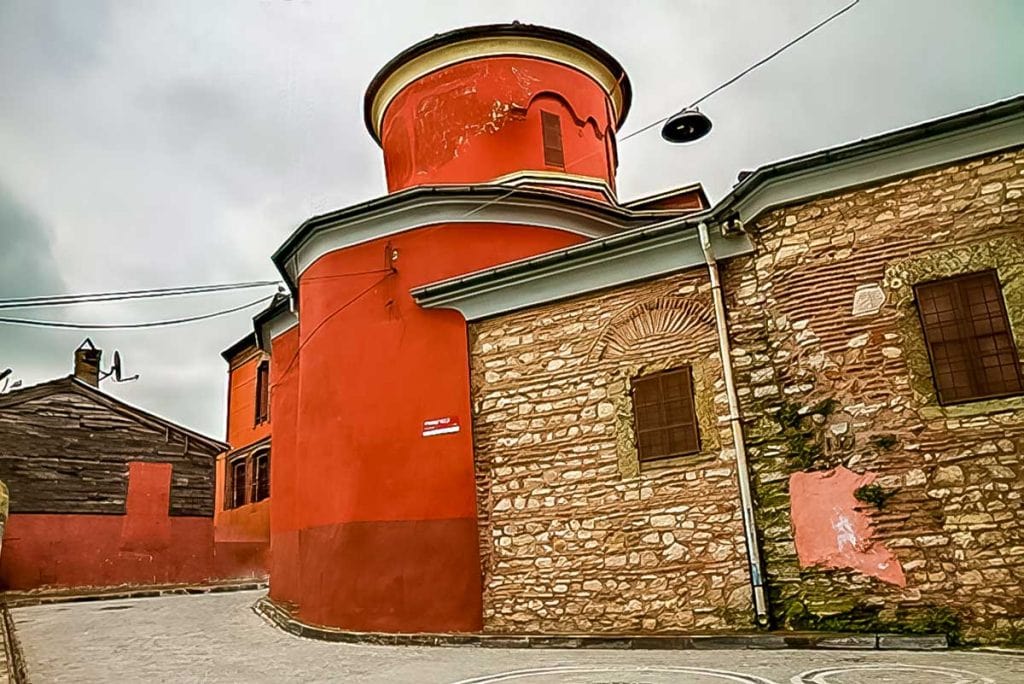 Saint Mary of the Mongols church a red painted building with a brick sided side portion. 