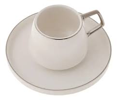 White porcelain turkish coffee cup with silver details on a white saucer