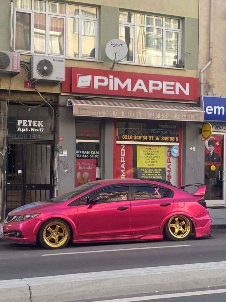 a hot pink sports car parked on the streets of Istanblul