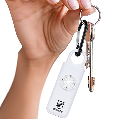 white keychain alarm on a keychain with keys being held up