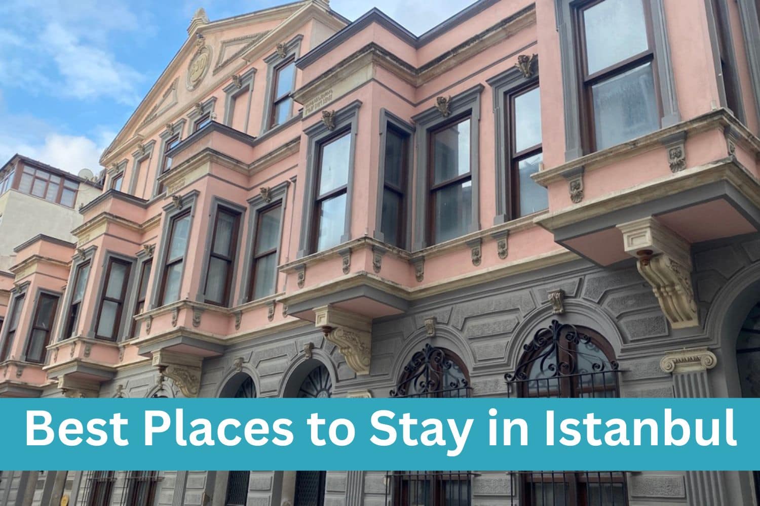 Best places to stay written on top of a old building in Istanbul that has brick on the bottom and painted pink on the top on a sunny day