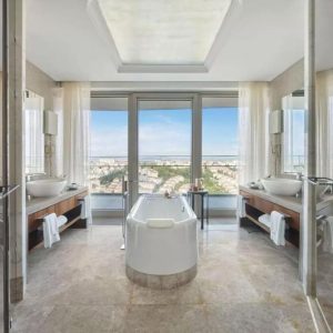 Epic view from an epic white tub in the middle of a luxurious bathroom with his and hers sinks on either side of the bathroom. 