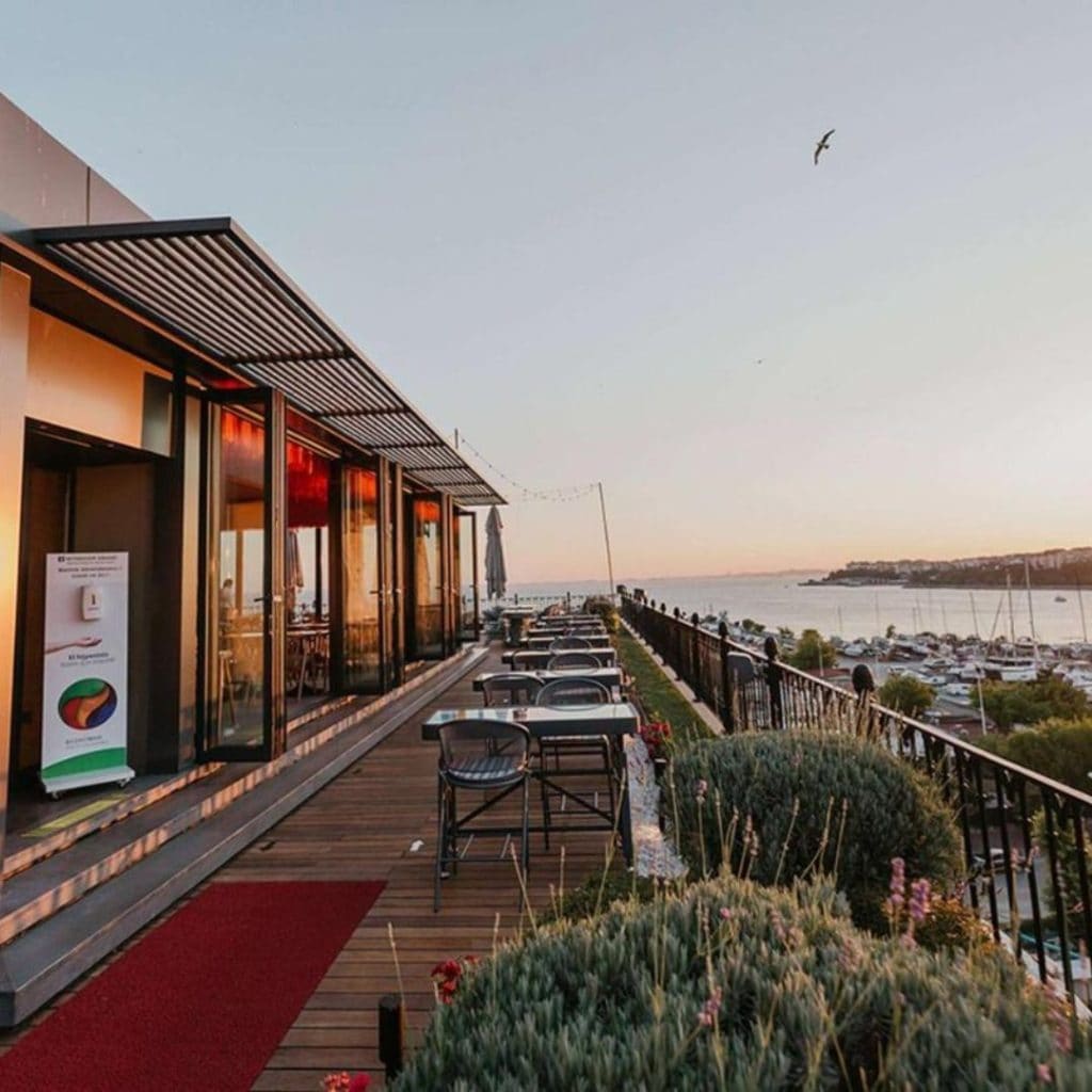 Beautiful view of the balcony seating at the rooftop restaurant at the Wyndham Grand at sunset with the harbor in the background