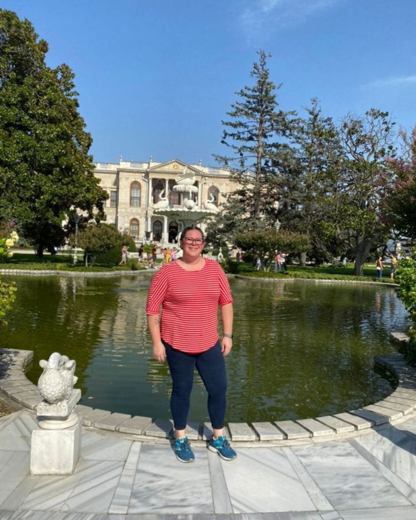 Kimberly on a visit to the Dolmabahce palace, standing in front of a pond which is in front of the palace. 