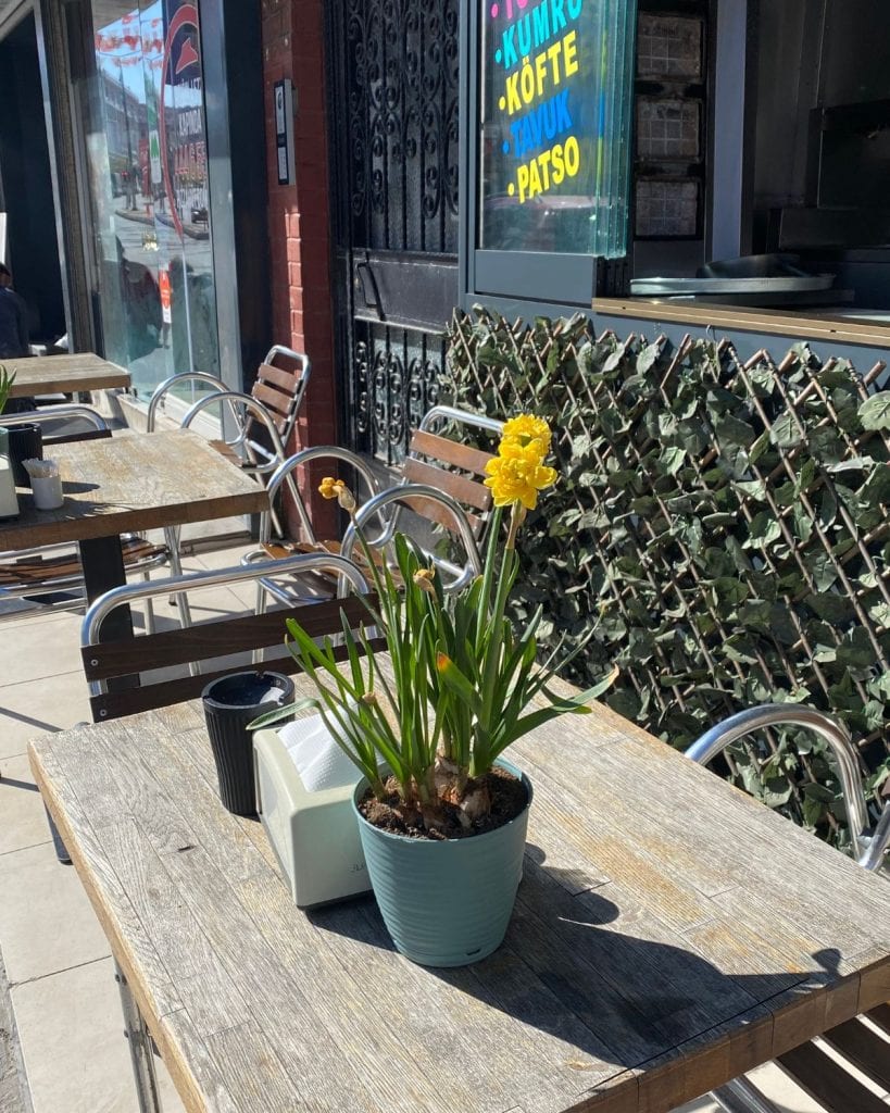 A potted yellow daffodil decorates a table at an outdoor cafe in Istanbul