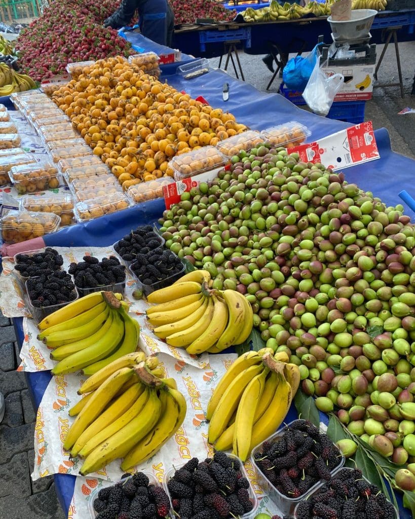 Black mulberries, green nectarines, loquats and bananas at an outdoor market in Spring