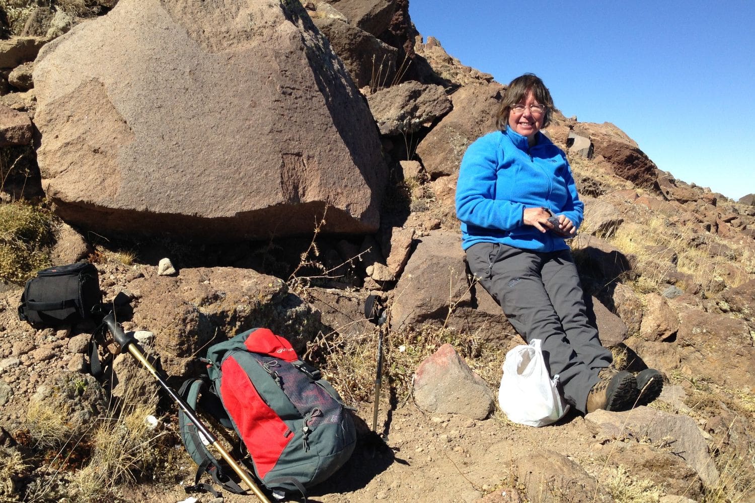 Pat Yale sitting on a rock while hiking on a sunny day