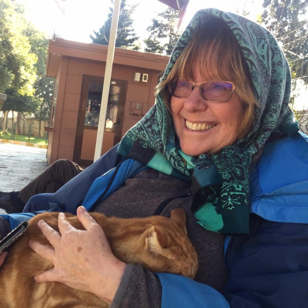 Pat Yale holds a cat in the courtyard of a mosque