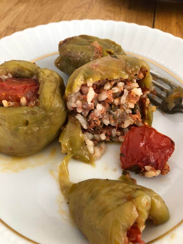 dolma on a plate. Green bell peppers stuffed with rice and tomato paste mixture.