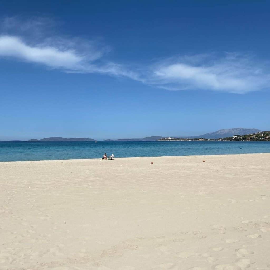 A white sand beach at Cesme, Izmir with the Aegean Sea and mountains in the distance.