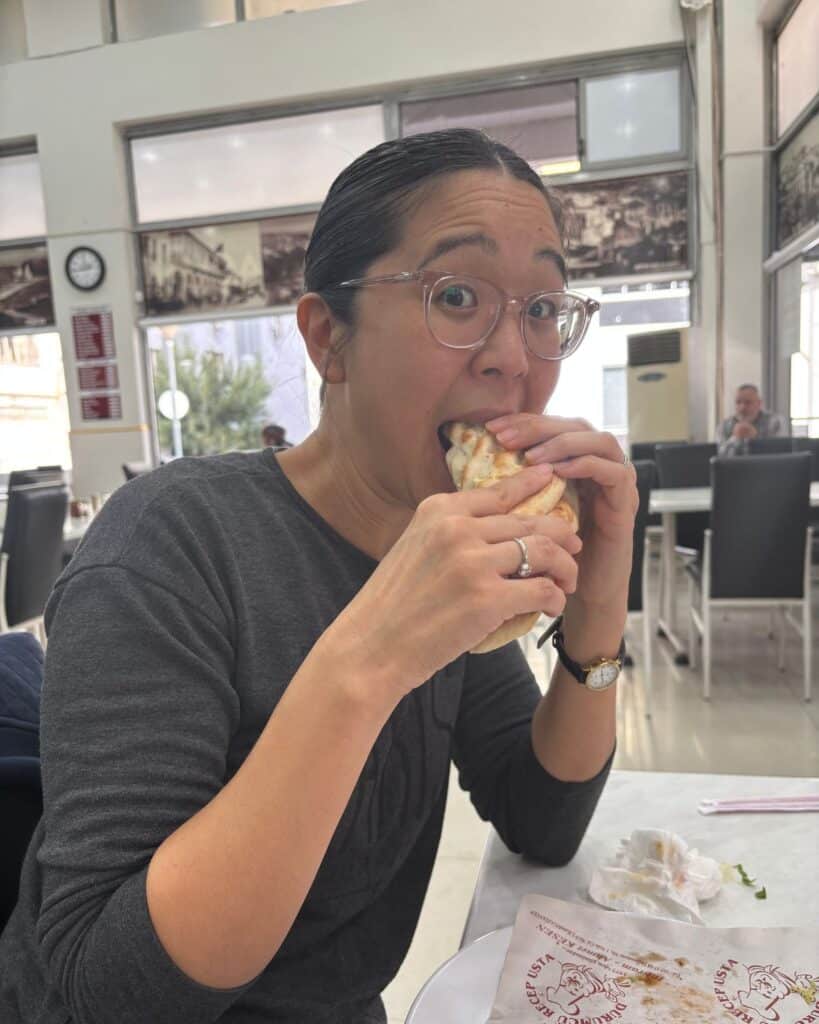 A woman eating a chickpea wrap at Durumcu Recep Usta in Gaziantep, Turkey.