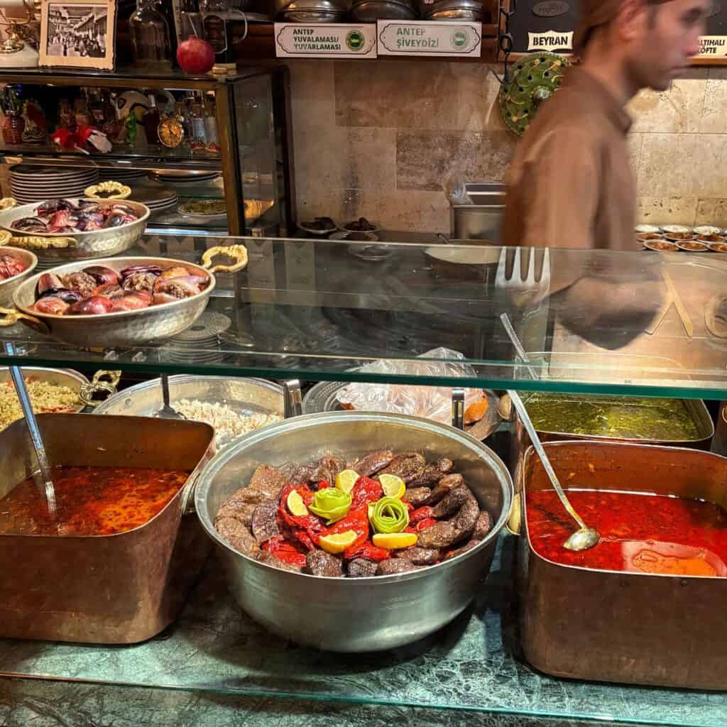 A restaurant counter with soups and other dishes ready to be served at Yesemek Restaurant in Gaziantep, Turkey.